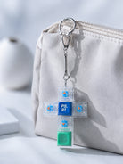 Psalm 91 cross light-up keycap keychain clipped to a beige pouch