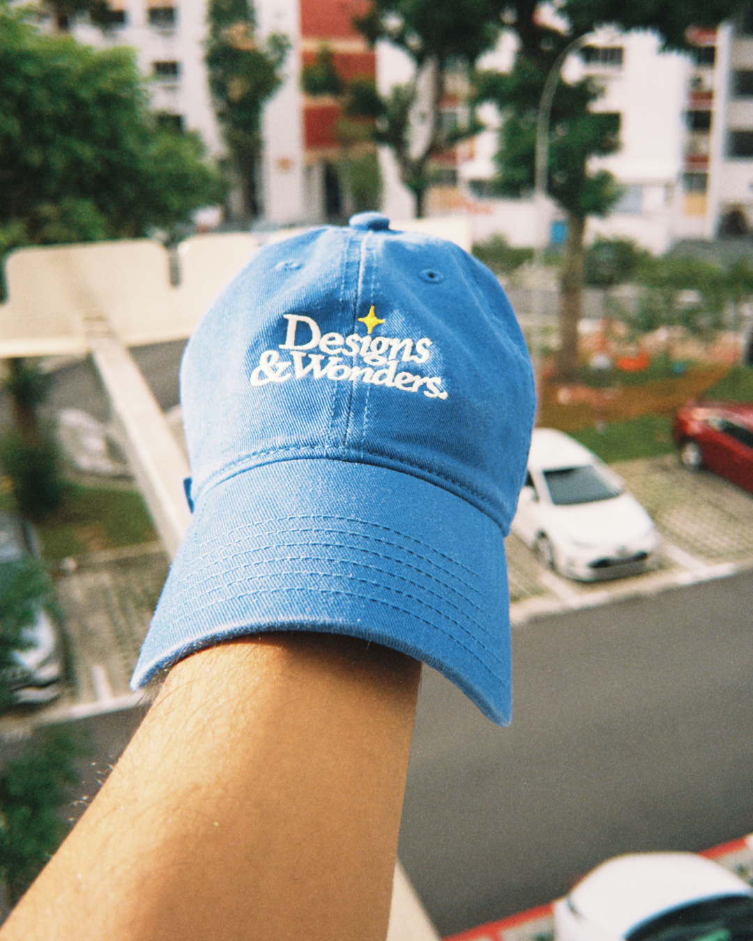 Designs & Wonders blue embroidered cap styled outdoors