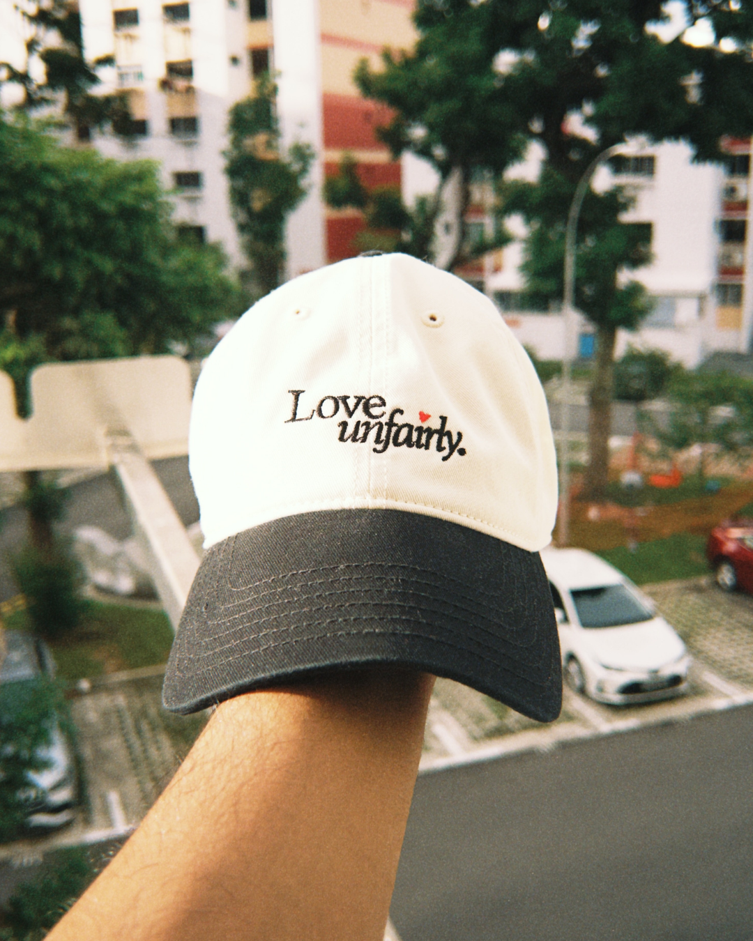 Love Unfairly cream and black cap styled outdoors