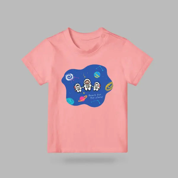 Pink kids’ T-shirt with Jesus and two little astronauts holding hands beneath the words Reach for the stars