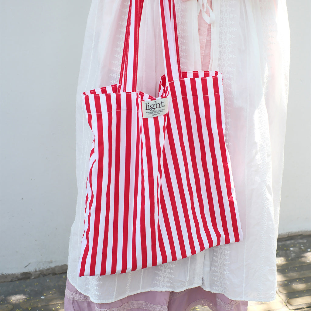 Red striped reusable cotton tote bag, eco-friendly and fashionable accessory for shopping and beach use.