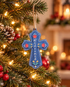 Blue Redeemed cross Christmas tree bauble hanging by string among warm festive lights