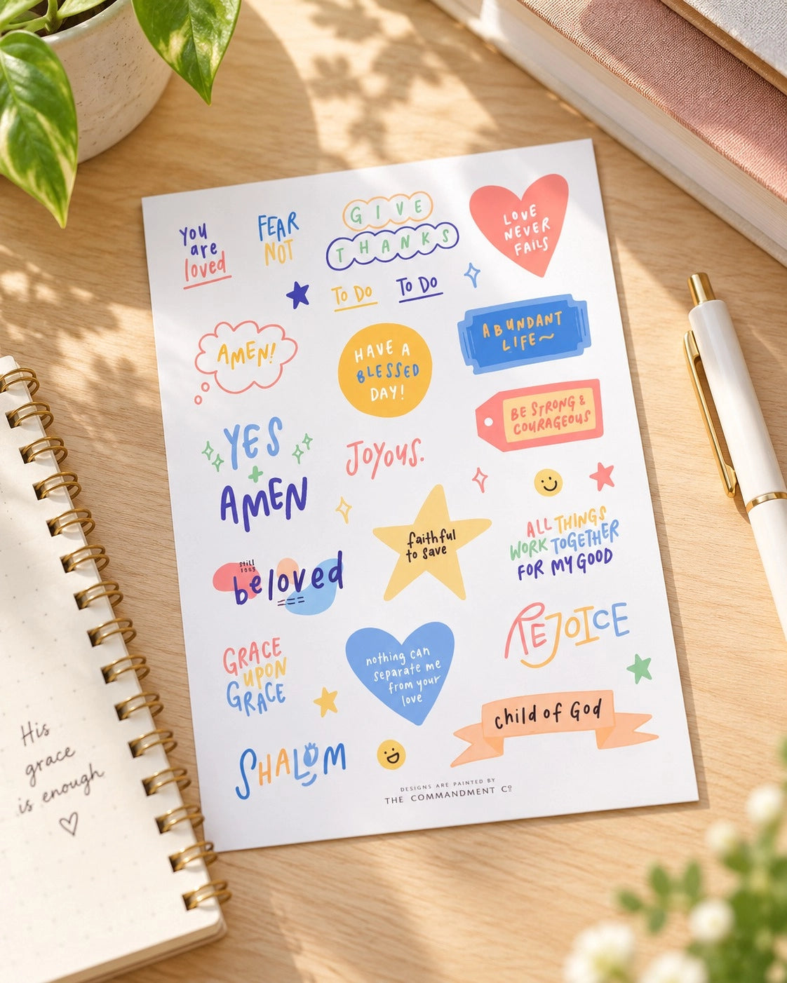 Rejoice Christian journaling sticker sheet with colourful faith phrases displayed on a sunlit desk.