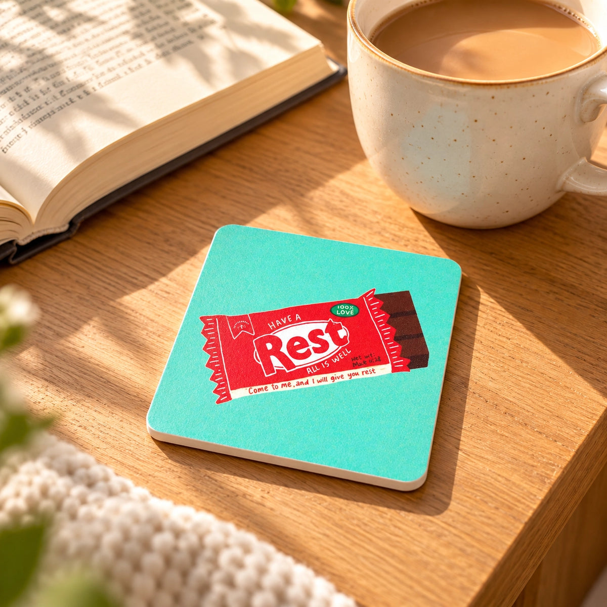 Rest Chocolate Bar Christian coaster styled beside an open Bible and coffee