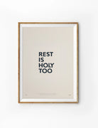 Rest Is Holy Too Christian poster with bold charcoal lettering on a warm neutral background