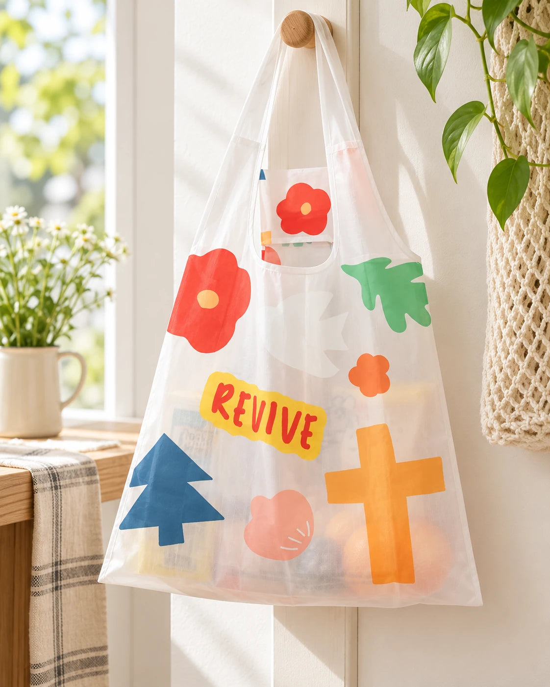 Revive reusable ecobag with colourful floral cross design hanging in a sunny home
