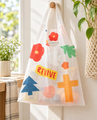 Revive reusable ecobag with colourful floral cross design hanging in a sunny home