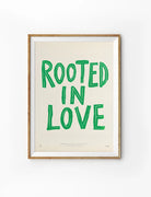 Rooted In Love Christian poster with bold green hand-drawn lettering on a warm neutral background