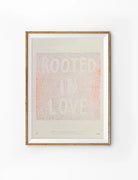 Rooted In Love Christian poster with soft coral textured lettering on a warm cream background