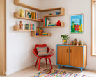 Rooted, Not Rushed poster displayed in a colourful reading corner with wooden shelves and a red chair