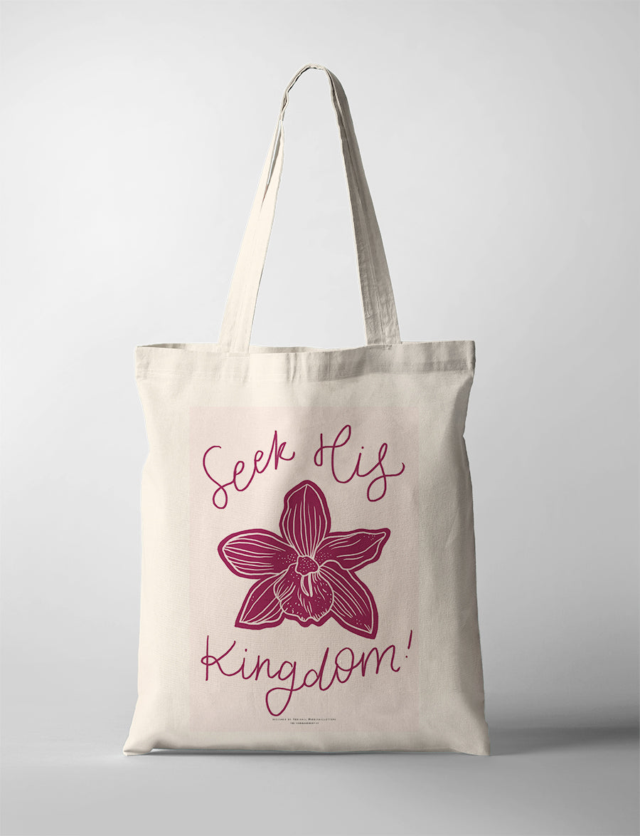 Christian tote bag featuring “Seek His Kingdom” with a pink background and orchid illustration