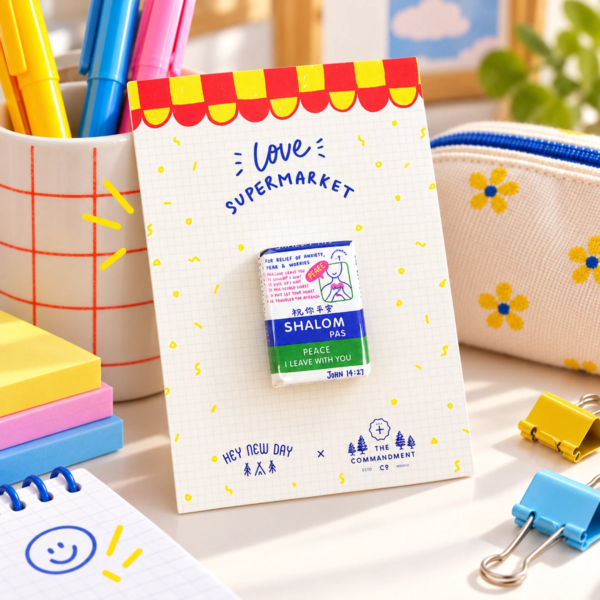 Shalom Pas Love Supermarket Christian pin displayed in a colourful desk lifestyle setting.