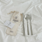 Stainless steel cutlery set including a spoon, fork, and chopsticks in a canvas pouch with the message "God loves you" and a Bible verse from Jeremiah 31:3.