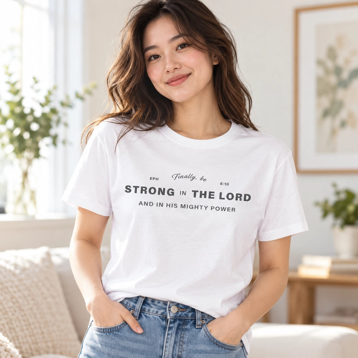 Strong in the Lord white Christian T-shirt worn in a bright casual home setting