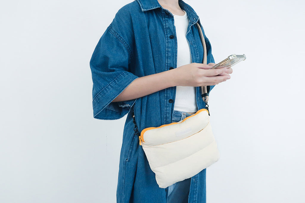 Person carrying the Oat Pong Pong Bag with a comfortable grip, showing its soft, compact design.