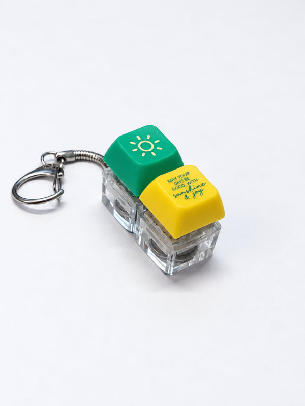 Sunshine and Joy light-up keycap keychain in green and yellow on a white background