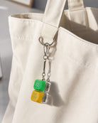 Sunshine and Joy keycap keychain clipped to a cream canvas tote bag