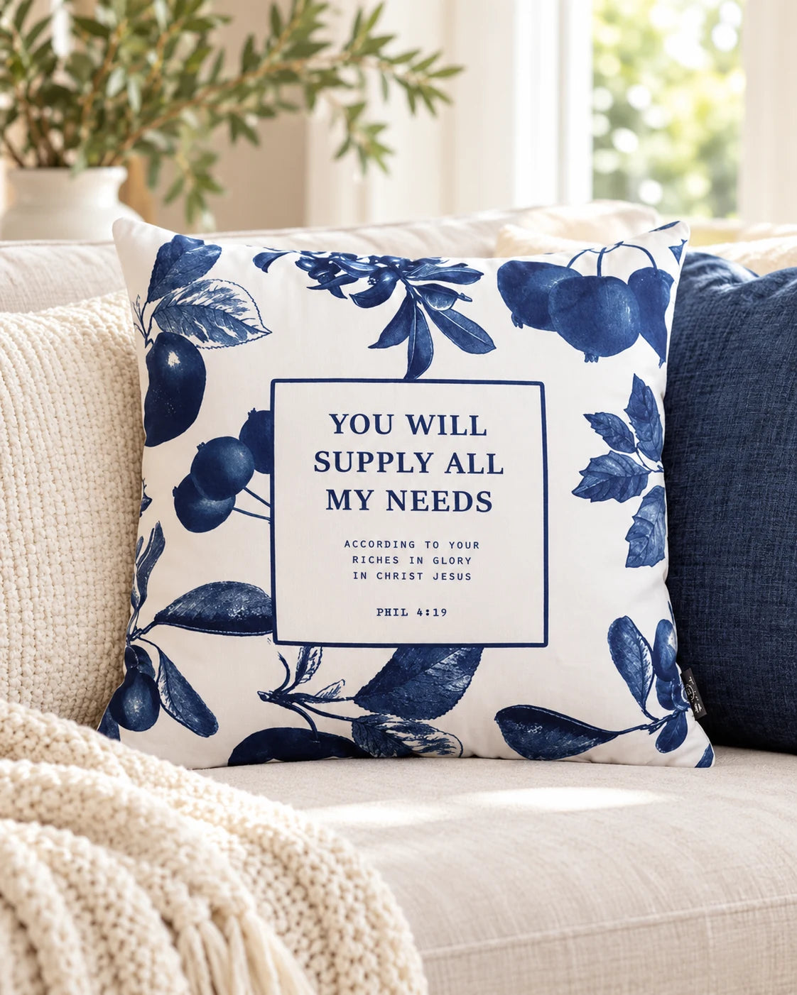 You Will Supply All My Needs blue floral Philippians 4:19 cushion cover on a cosy neutral sofa