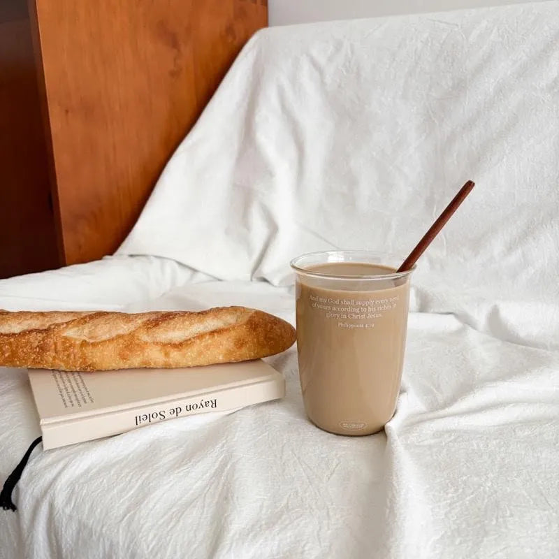 Philippians 4:19 Christian glass cup filled with latte beside bread and a book in a cosy setting