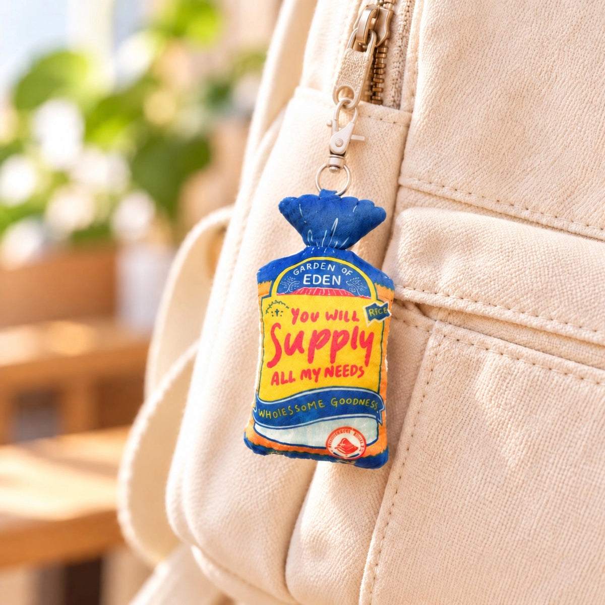 Supply Bread faith-inspired plushie keychain hanging from a cream canvas bag.