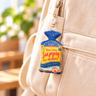 Supply Bread faith-inspired plushie keychain hanging from a cream canvas bag.