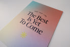 A detailed view of a postcard with a gradient background and the encouraging message "The Best Is Yet To Come," along with the phrase "Take Your Time," designed to inspire hope and positivity.