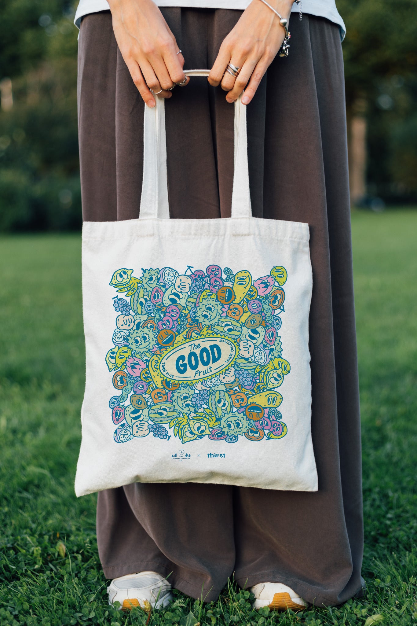 Person carrying The Good Fruit coloured tote bag outdoors