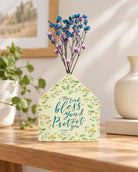 The Lord Bless You and Protect You little house vase with blue and purple dried flowers on a wooden table