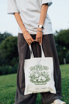Person carrying The Lord Is My Shepherd Psalm 23:1 tote bag outdoors