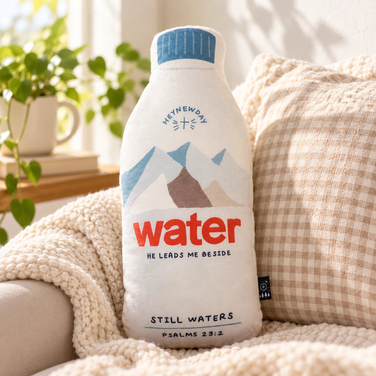The Still Waters bottle-shaped plush toy styled on a cosy sofa