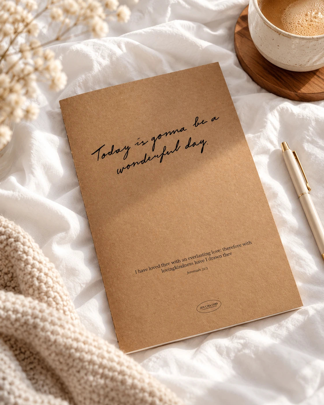 Today Is Gonna Be a Wonderful Day kraft-cover A5 notebook on soft white bedding beside a pen and a cup of coffee
