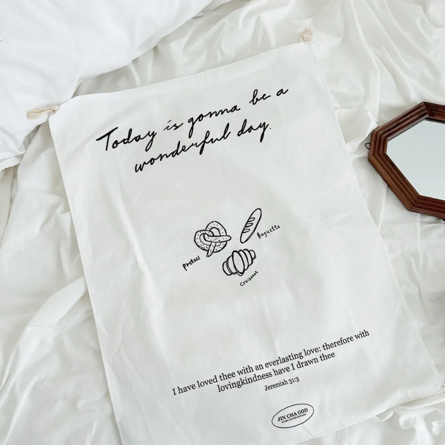Uplifting wall tapestry with the message "Today is gonna be a wonderful day," featuring hand-drawn pretzel, baguette, and croissant illustrations, and Jeremiah 31:3 Bible verse, perfect for Christian home decor.
