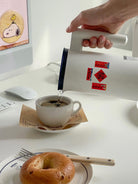 Mini Chinese New Year couplet stickers decorating kettle and coffee setup with festive red accents