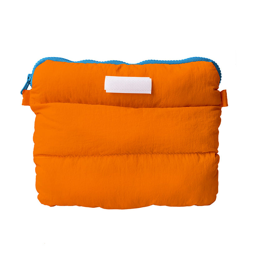 Front view of the Orange Pong Pong Bag with a blue zipper, showcasing its compact and versatile design.