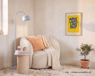 Walk Light Love Deep Christian poster framed above a cosy reading chair in a warm sunlit interior