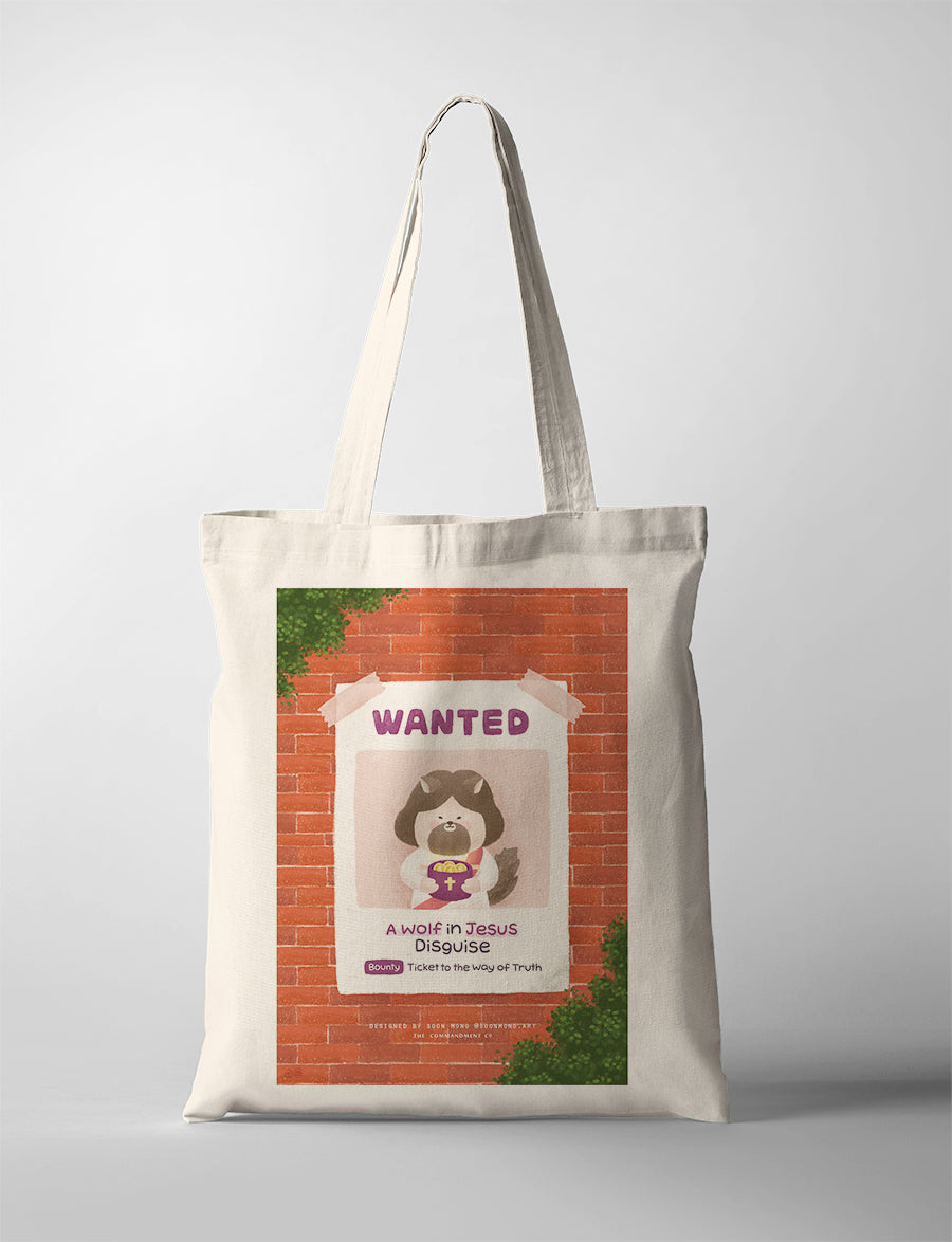 A playful illustration of a 'Wanted' poster featuring a cute character resembling Jesus holding a basket of treasures. The tote bag humorously reads 'A Wolf in Jesus Disguise' and 'Ticket to the Way of Truth,' set against a brick wall background.