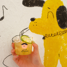 Glass mini cup with "We are not alone" design, filled with a refreshing drink, symbolizing connection