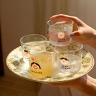 Four glass mini cups with designs and messages like "We are one" and "We are growing," symbolizing unity and love.