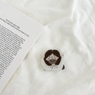 Close-up of the YA! Jesus hand-drawn phone grip featuring a cute Jesus illustration beside an open devotional page