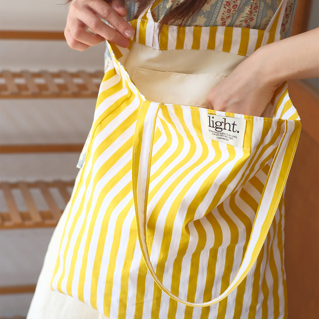 Yellow striped cotton tote bag, a reusable, eco-friendly, and stylish accessory for sustainable shopping.