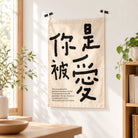 You Are Loved Christian wall tapestry displayed in a bright natural home interior with plants and wooden furniture
