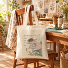 Your Right Hand Shall Hold Me Fast Christian canvas tote bag resting on a wooden chair in a sunlit craft room