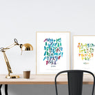 A3 beautiful calligraphy poster placed standing next to a smaller A4 sized calligraphy poster on a wooden table. Modern Christian home interior design ideas.