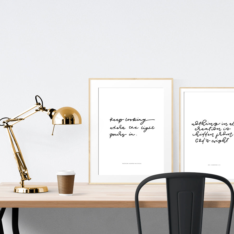 A3 beautiful calligraphy poster placed standing next to a smaller A4 sized calligraphy poster on a wooden table. Modern home interior design ideas.