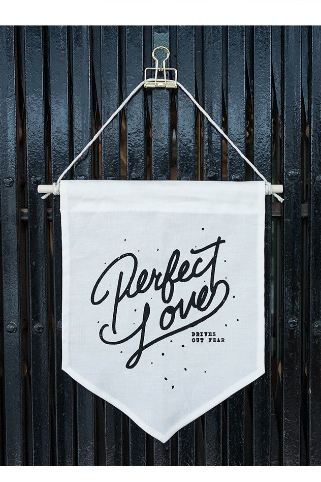 Perfect love drives out fear on white banner of victory.