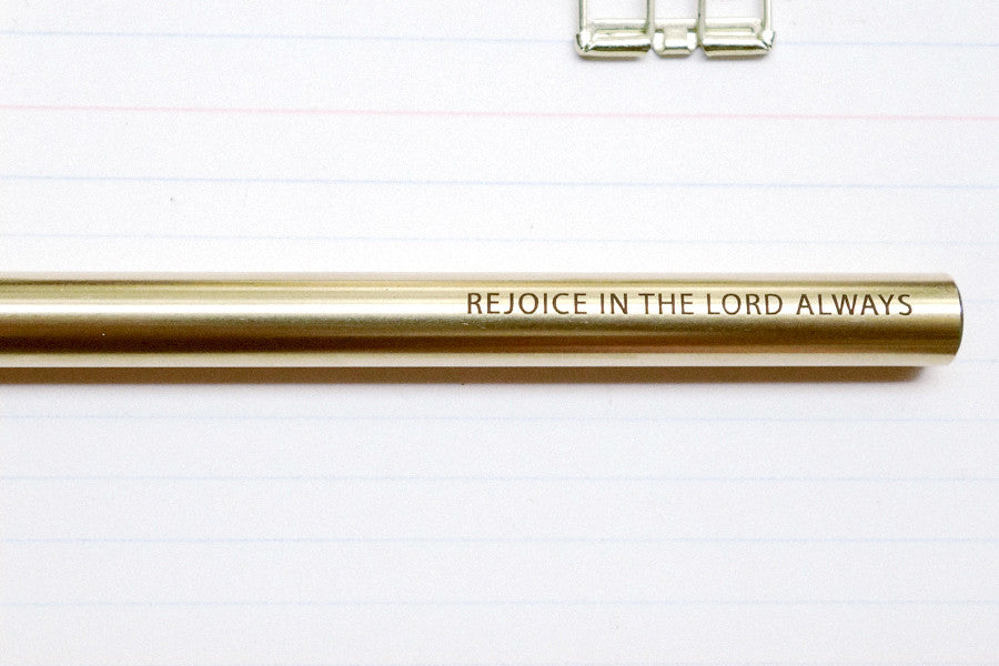 Brass pen barrel with the message 'Rejoice in the lord always'.