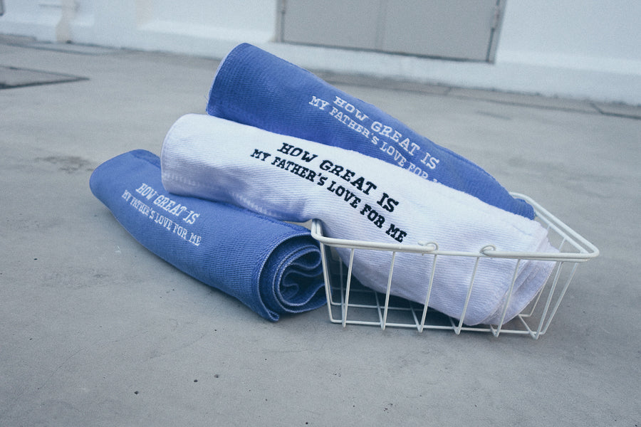 Blue and white sports towel in a white mesh basket on floor