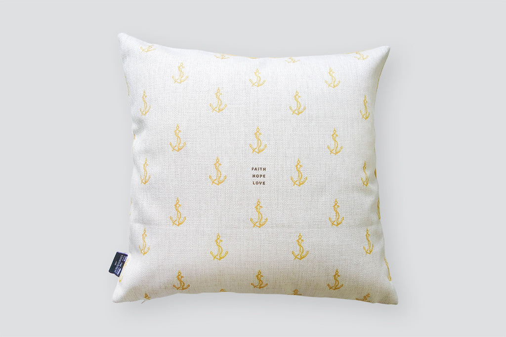 The back of cushion cover features the same design but white with yellow anchor details and brown small fonts. Nautical home design ideas.