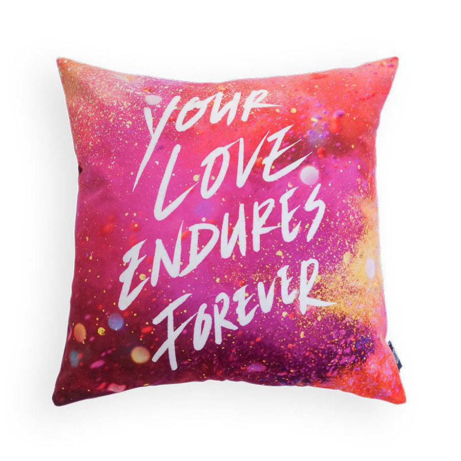 Pillow cover with the verse 'Your love endures forever' in white. On pink glitter and light background