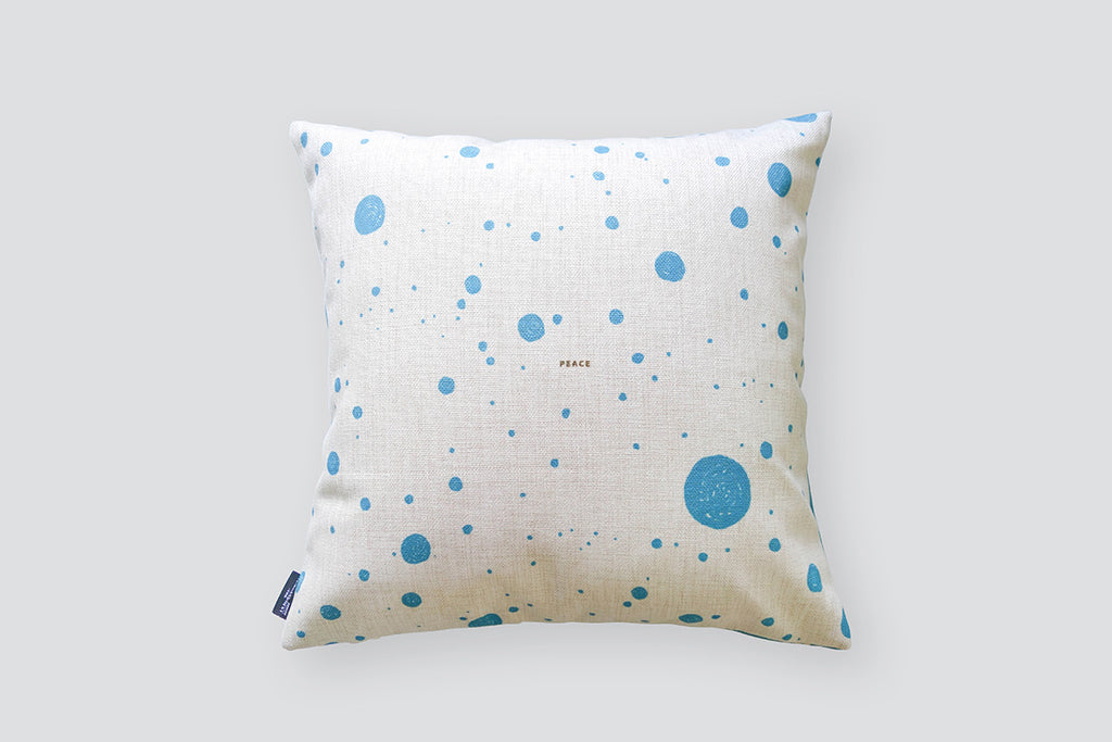 The back of the cushion cover features blue dots on gray background